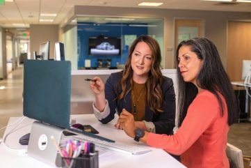 Photo by LinkedIn Sales Solutions two women sitting at a table looking at a computer screen
